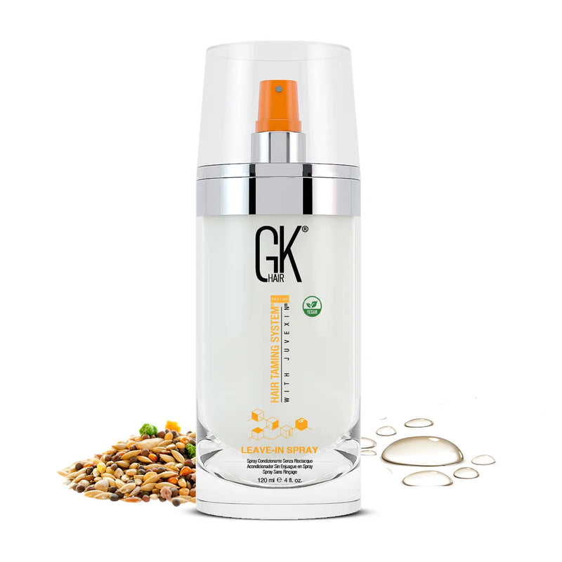 GK Hair Leave-In Spray 120 ml clear bottle with orange nozzle and vegan badge, beside mixed seeds and oil droplets