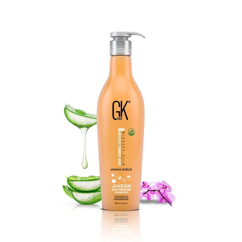GK Hair Juvexin Color Protection Shampoo 650 ml orange pump bottle beside dripping aloe vera slices and a pink orchid