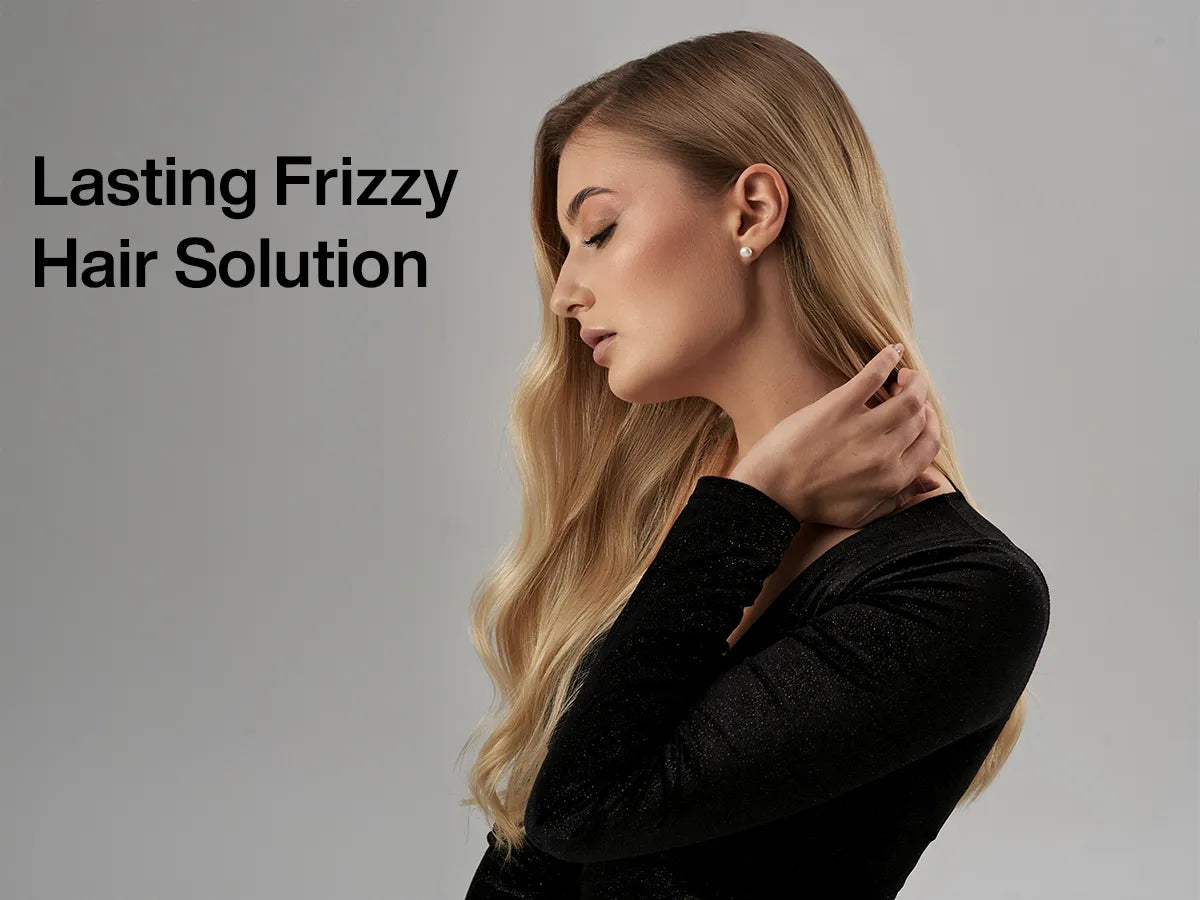 A woman with long, wavy hair dressed in a black top poses gracefully against a neutral background, promoting a frizz-control product.