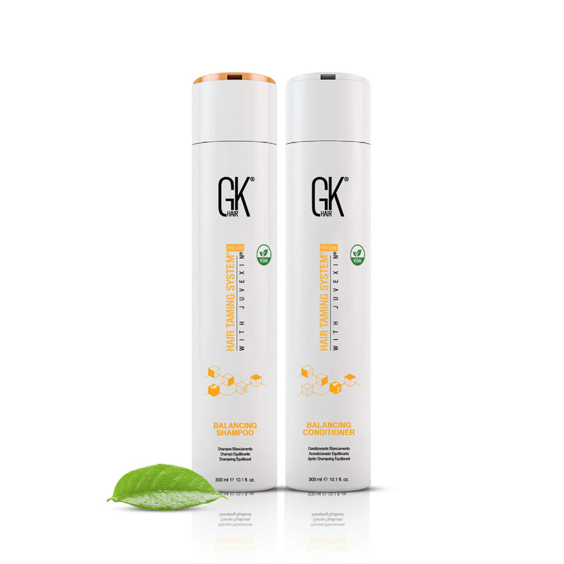 GK Hair Balancing Shampoo with copper cap beside Balancing Conditioner, both 300 ml bottles, with a green leaf on white
