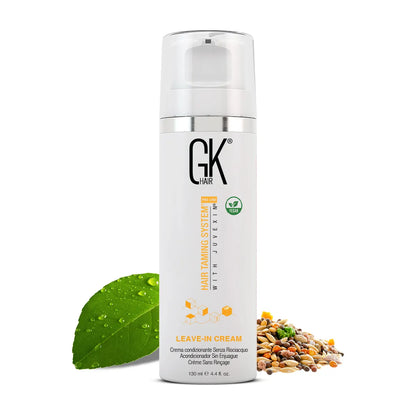 GK Hair Leave-In Cream 130 ml white pump bottle with vegan badge, beside a green leaf and a pile of mixed seeds