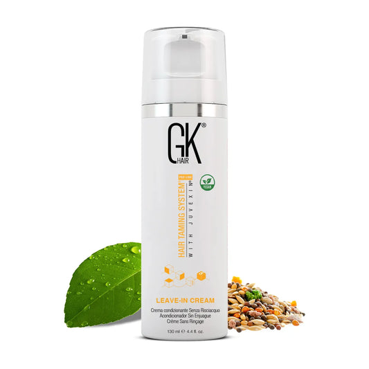 GK Hair Leave-In Cream 130 ml white pump bottle with vegan badge, beside a green leaf and a pile of mixed seeds
