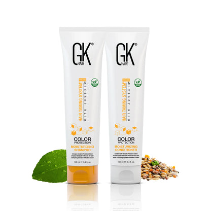 GK Hair Moisturizing Shampoo 100ml  is centered. Surrounding it are a green leaf and seeds, emphasizing natural ingredients in a white background.