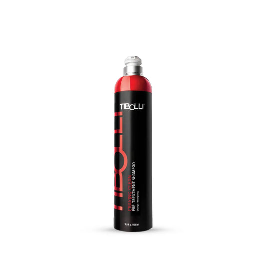 Tibolli Pre-Treatment Shampoo in a tall black bottle with a red shoulder and silver cap, on white