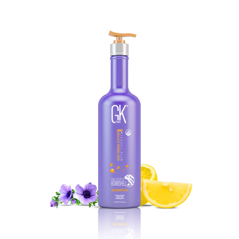 GK Hair Silver Bombshell Shampoo purple 710 ml bottle with gold pump beside purple anemones and lemon slices on white