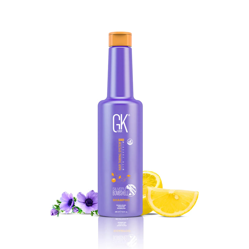 GK Hair Silver Bombshell Shampoo 280 ml purple bottle with orange cap beside purple anemones and lemon slices on white