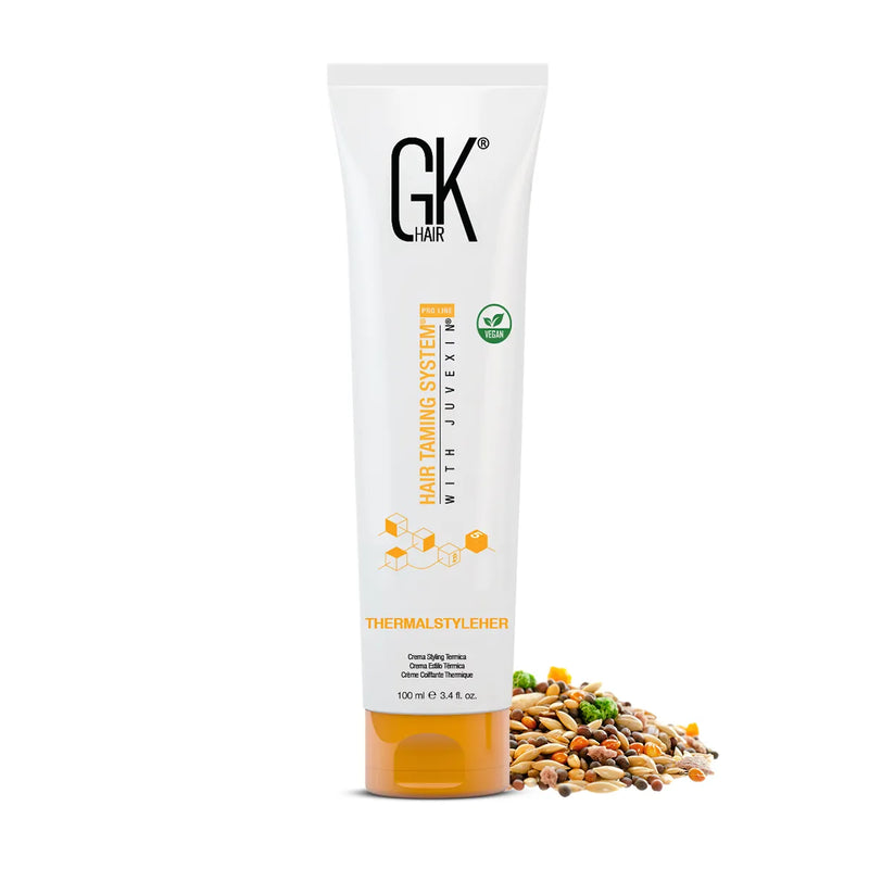 GK Hair ThermalStyleHer Cream 100 ml white tube with orange cap beside a pile of mixed seeds and grains on a white background